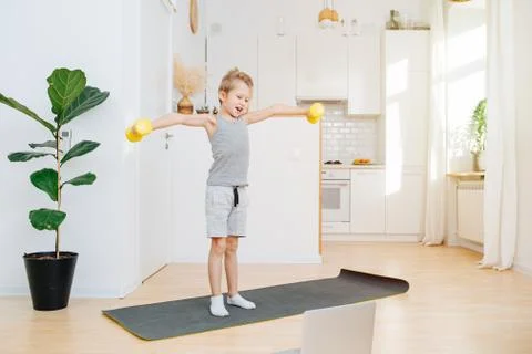 Boy schoolboy doing workout looking into laptop Stock Photos