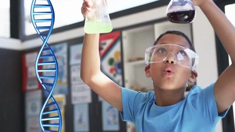 Boy in science lab raising flasks to light testing liquids comparing color as Stock Footage 333078192