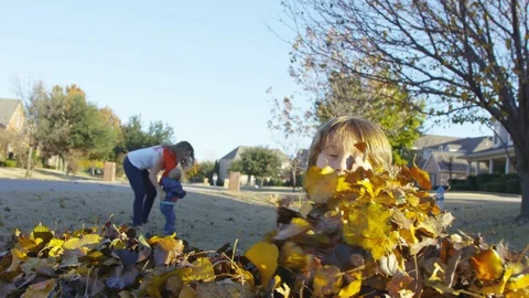 Boy scoops up leaves and throws them into the camera lens Video stock 94008021