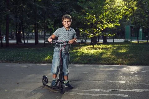 Boy with a scooter in the park Stock Photos