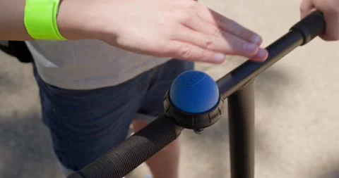 Boy on a scooter puts a solid bracelet Stock Footage 339321675