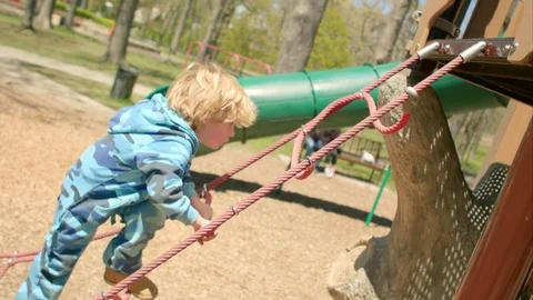 The boy scrambles up the stairs in the playground Stock-Footage 75981388
