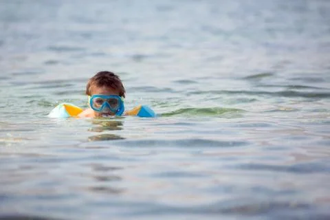 Boy with scuba diving equipment, swimming in the sea Stock Photos