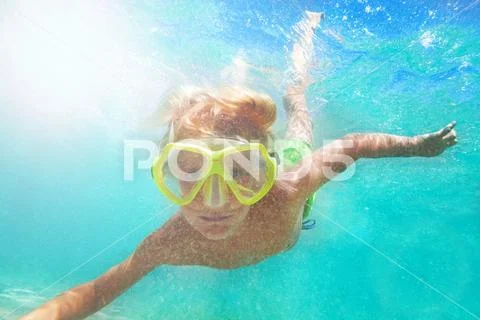 Boy in scuba mask swimming underwater Stock Photos