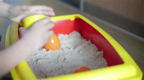 Boy sculpts sand shapes using the bright orange and yellow molds. Stock Footage 68222680