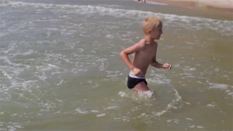 Boy in the sea on the waves Stock Footage 71821165