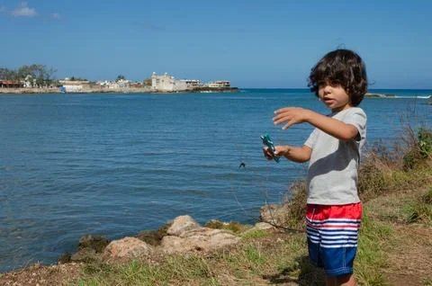 Boy on the seashore in a bay talking Stock Photos