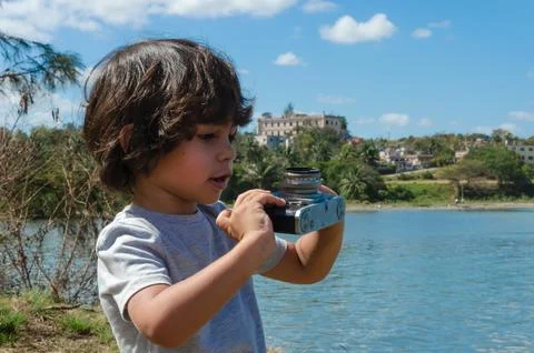 Boy at the seaside checking his lens Stock Photos
