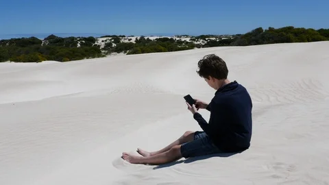 Boy sending message home from remote desert location 스톡 동영상 106939770