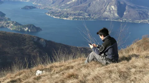 Boy sends message with the phone in the mountains Stock Footage 59699162