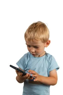 A boy with a serious expression is dialing a number on the phone Stock Photos