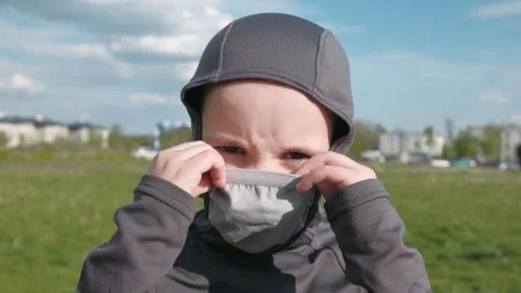 A boy with a serious look wears a protective mask outdoor Stock Footage 131101687