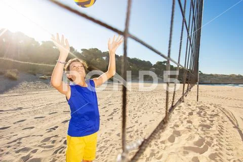 Boy serving the ball during beach volleyball game Stock Photos