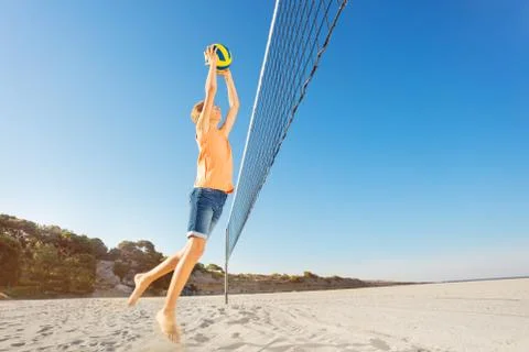 Boy serving the ball during beach volleyball game Stock Photos