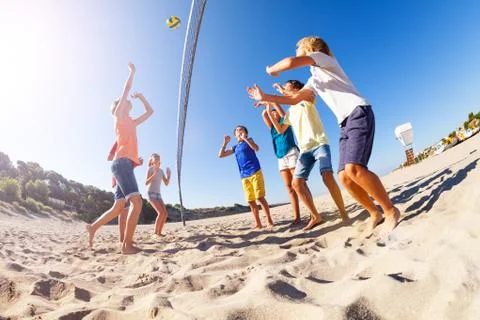 Boy serving the ball during beach volleyball match Stock Photos