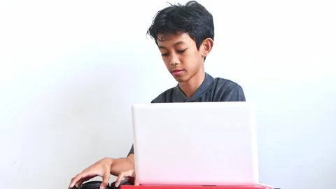 Boy setting up his laptop and putting on headphones for an online meeting or Stock Footage 324947331