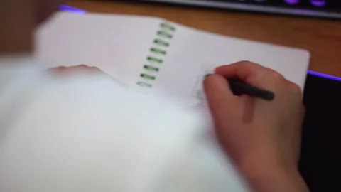 Boy shading a rectangle in a notebook with a pencil close-up Video stock 307121799