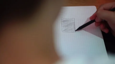 Boy shading a rectangle in a notebook with a pencil close-up1 Stock Footage 307121800
