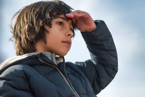 Boy shielding eyes looking forward to the future Fotos Stock