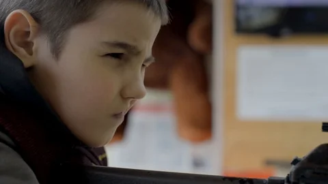 A boy in a shooting range aims from a rifle at a target, close-up Stock Footage 128242242