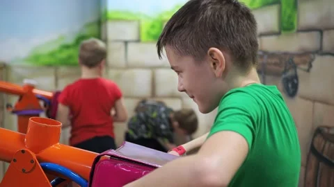 A boy shoots balls from a toy machine gun. children's entertainment center. war Stock Footage 171340932