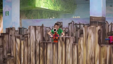 A boy shoots soft balls from a toy cannon. children's entertainment center. war Stock Footage 171676653