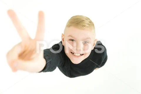 The boy show two finger to the camera. View from above Stock Photos