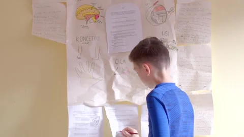 A boy showcases creativity by drawing on a wall, illustrating art Vídeos de archivo 311205215