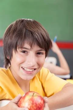 Boy showing an apple Fotos de archivo