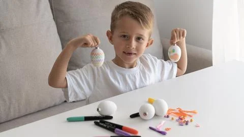 Boy Showing Hand Painted Easter Eggs at Home Stock Photos