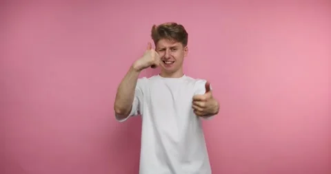 Boy showing thumb up on pink background. Person shows various hand gestures.. Stock Footage 317327974