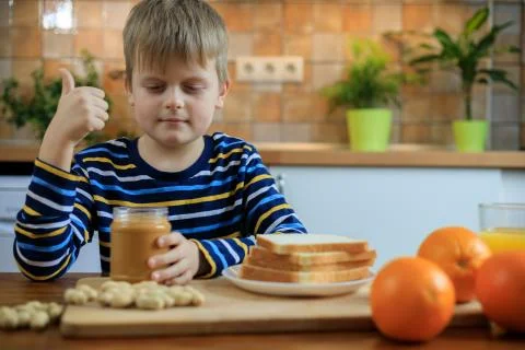 Boy is showing thumbs up when preparing to eating sandwich with peanut butter Stock Photos