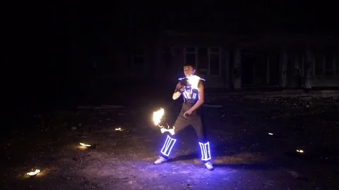 Boy shows different tricks with burning pois rotation at evening fire show. Vídeo Stock 82410811