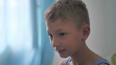 The boy shows his tongue, looks at the camera, gestures with his mouth and Stock Footage 204792809