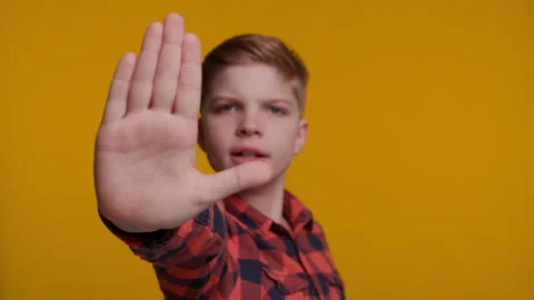 Boy Shows Palm as Stop Sign at Camera on Yellow Background Stock Footage 316685529