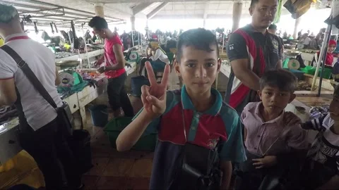 Boy shows V and Thumbs up sign, Fish market, Lahad Datu, Sabah, Borneo, Malaysia Stock Footage 170686796