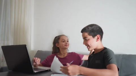 Boy shows written work to friend who playfully slaps his head in reaction Stock Footage 305712137