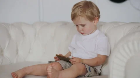 Boy sit on the sofa and watch cartoon Stock Footage 68402846