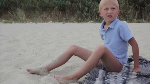 Boy sits on the beach in the sand Stock Footage 71818850