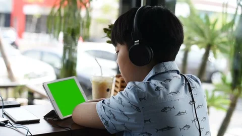 Boy Sits on chair Using Tablet wearing headphones. Stock Footage 87674550