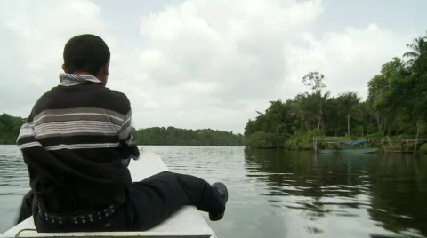 Boy sits on front of boat Stock Footage 513881