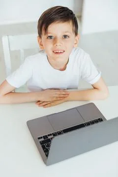A boy sits in a lesson at a computer a student school learning online Foto stock