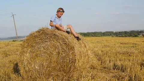 Boy sits on the straw Video stock 128053603