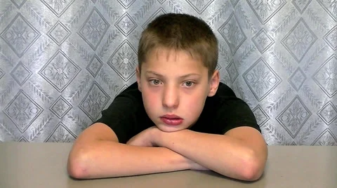 Boy sits at the table and looking sad look Stock Footage 67856912