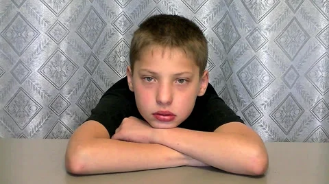 The boy sits at the table - The boy shakes his head - The boy did not agree Stock Footage 67857825