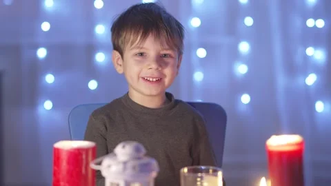 A boy sits at a table with candles Stock-Footage 267941819
