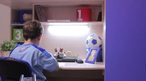 Boy sits at a table, playing, drawing Stock Footage 50811759