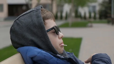 The boy sitting on the bench. he ate his candy and very much surprised Stock Footage 130117934