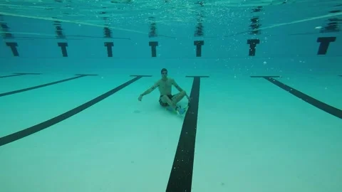 Boy sitting at the bottom of the pool Video stock 196807780