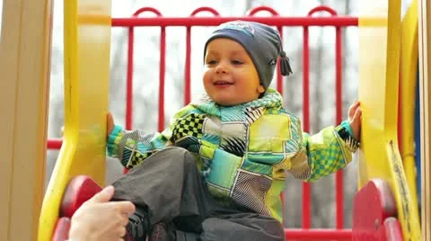 Boy sitting on children's slides Vídeo Stock 12401817